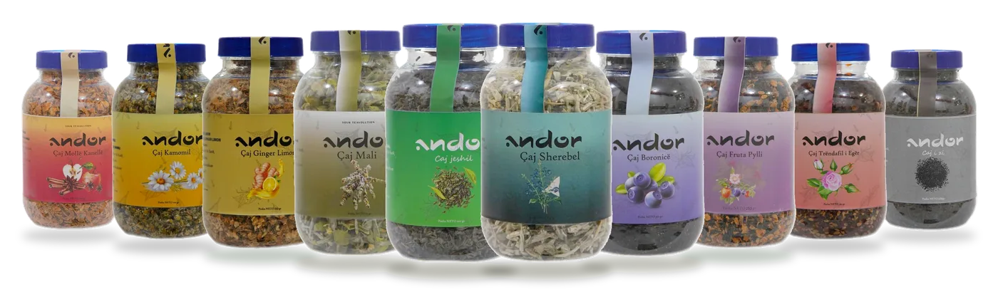 Të dhjetë çajrat andor të rreshtuar bashkë: kavanoza të tejdukshëm me etiketa nga e kuqja, e verdha dhe ari te jeshilja, gjelbër-kaltërosha, lejlaku e gri.